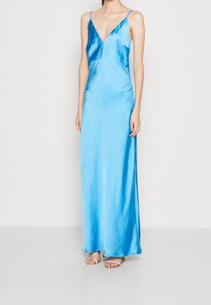 Sukienka maxi z satynowego niebieskiego materiału, z cienkimi ramiączkami, głębokim dekoltem w kształcie litery V oraz gładką fakturą, posiadająca boczne rozcięcie i zwiewną sylwetkę.