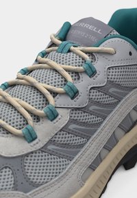 Γκρι και τιρκουάζ πεζοπορικό παπούτσι Merrell με επάνω μέρος από δίχτυ, μπεζ κορδόνια περασμένα μέσα από τιρκουάζ θηλιές και ορατή υφασμένη λαστιχένια σόλα.