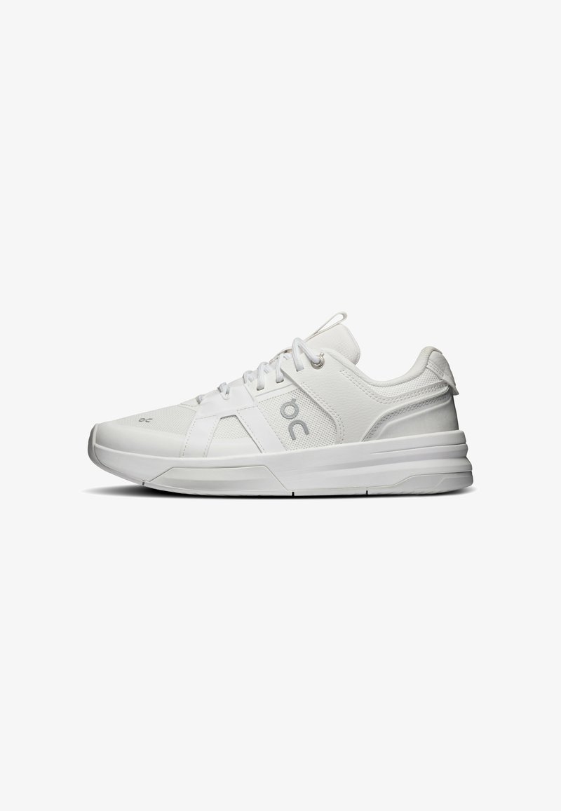Baskets blanches de sport avec empiècements en mesh et cuir, design à lacets, semelle amortie et logo sur le côté, vues de profil.