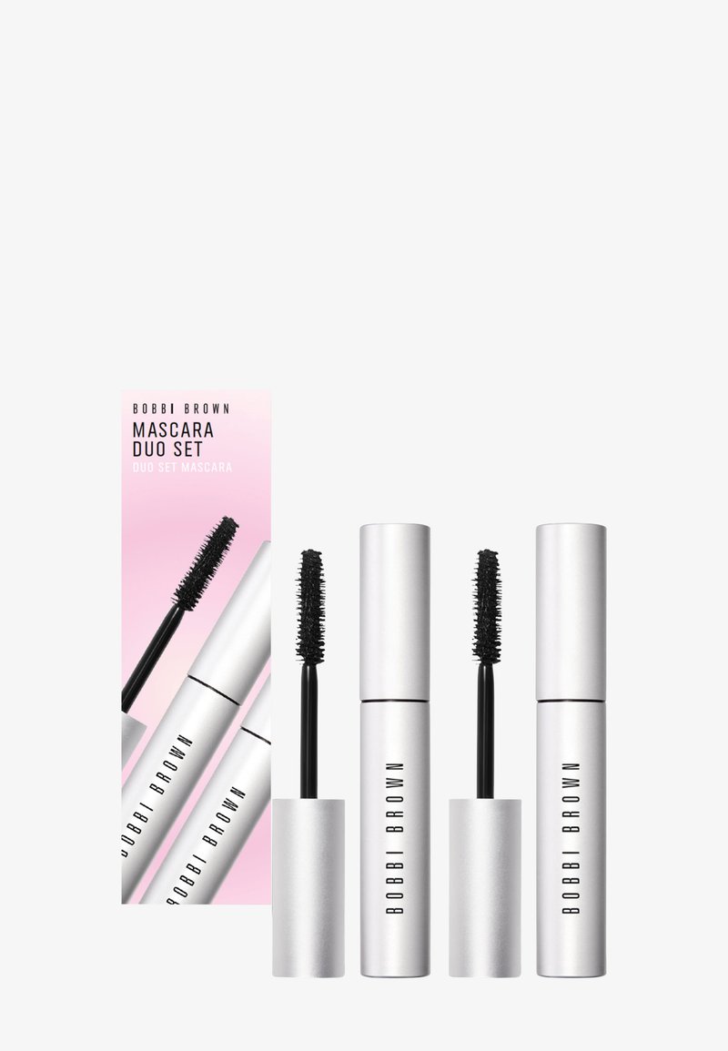 Le coffret duo de mascaras Bobbi Brown présente trois tubes cylindriques argentés avec des brosses noires, emballés dans une boîte rose affichant le nom du produit.