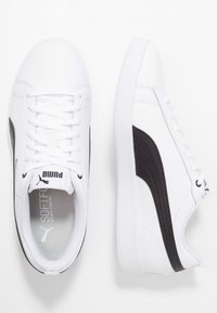 Białe sneakersy Puma z czarnym paskiem, sznurowane z przodu, z wyściełanym wnętrzem oznaczonym "SOFTFOAM Optimal Comfort".