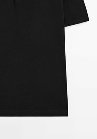 T-shirt in cotone nero con maniche corte, caratterizzato da un collo tondo, una texture liscia e un orlo dritto senza alcun motivo o dettaglio visibile.