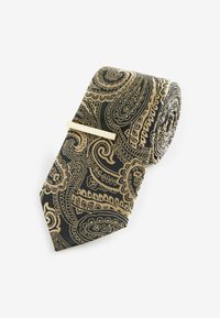 Svila kravata s uzorkom paisley u zlatnoj i crnoj boji. Ima glatku teksturu i elegantan držač za kravatu. Rolana za izlaganje.