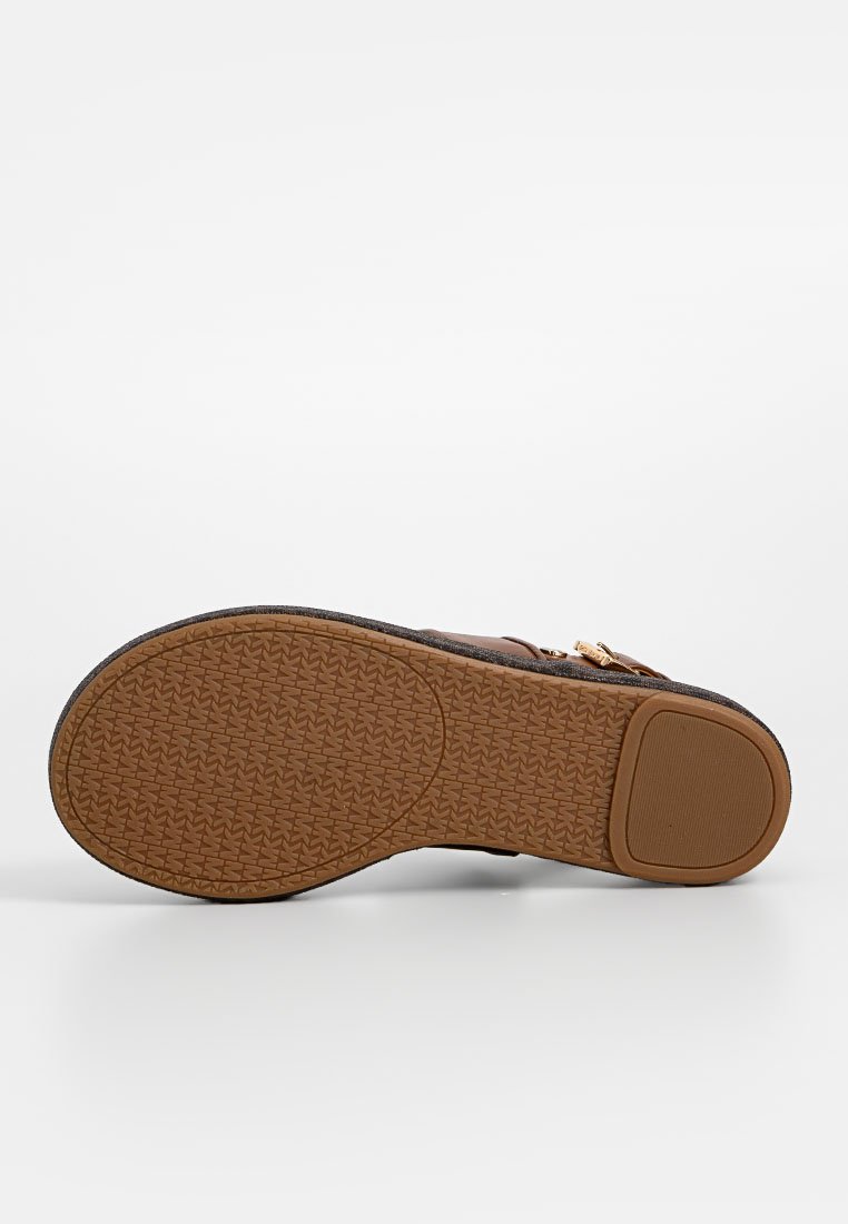 Sandalo marrone con una suola in gomma testurizzata e accenti in metallo dorato. La parte superiore presenta un tessuto morbido e un design per una vestibilità comoda.