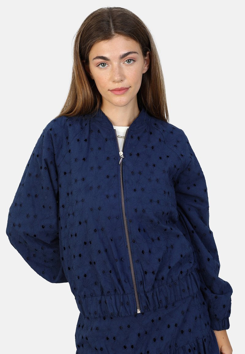 Marineblå bomberjakke med lynlåsfortil, prydet med en broderet tekstur med udskårne blomsterdesigns samt elastiske manchetter og talje.