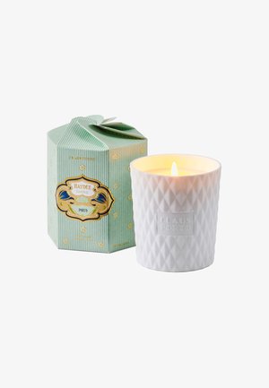 Weißer, strukturierter Kerzenhalter mit einem Diamantmuster, der einen angezündeten Docht neben einer grün gestreiften, sechseckigen Box mit dekorativen Akzenten zeigt.