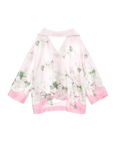 Ανοιχτό ροζ μεταξωτό μπλουζάκι με λευκό ανθισμένο μοτίβο, πράσινα φύλλα, φαρδιά γιακά, μανίκια τριών τετάρτων και ροζ πουά διακοσμητική λεπτομέρεια στα μανίκια και στο τελείωμα.