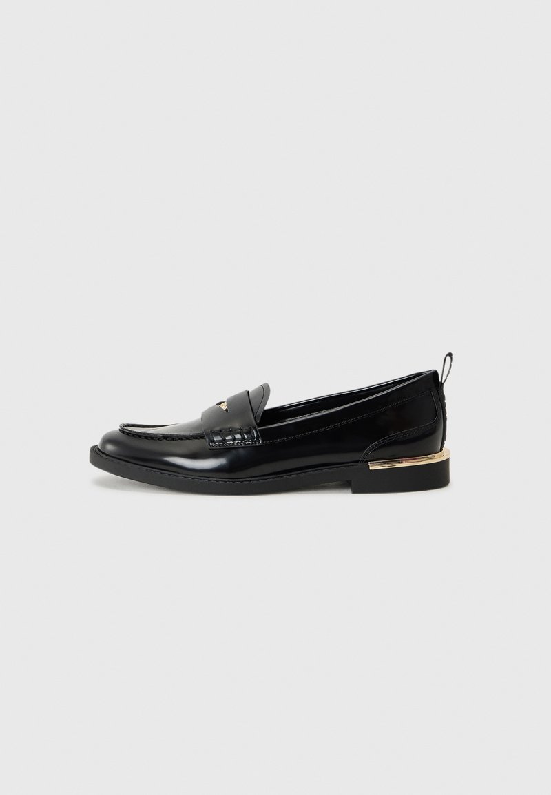Zwarte lakleren loafers met een afgeronde neus, een decoratieve band en een gouden accent op de hak. Gladde textuur met gestikte details.