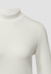 Witte lange mouwen turtleneck shirt gemaakt van een soepele, lichte stof. Het heeft een getailleerde pasvorm en minimale naaddetails.