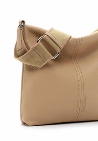 Borsa a tracolla in pelle tan con una texture liscia, forma curva e una tracolla in tela a contrasto con fibbia in metallo e dettagli di cucitura.