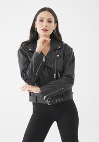 Černá kožená moto bunda s asymetrickým zipem, stříbrnými detaily a páskem v pase. Obsahuje kapsy na zip a texturovaný povrch.