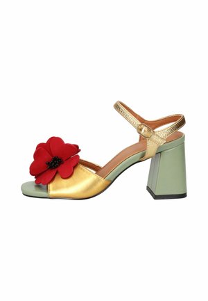 Sandalo con punta aperta con cinturini dorati, tacco a blocco verde e grande decorazione a fiore rosso sulla fascia anteriore.
