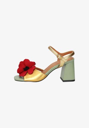 Sandalo con punta aperta con cinturini dorati, tacco a blocco verde e grande decorazione a fiore rosso sulla fascia anteriore.