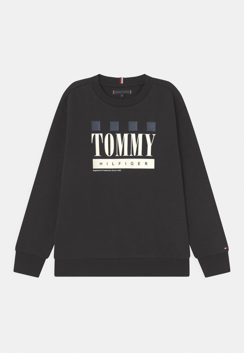 Sweat-shirt noir à col rond, arborant un grand texte "TOMMY HILFIGER" et quatre carrés à motifs bleus. Poignets et ourlet côtelés.