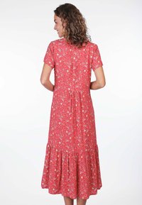 Rotes Blumenkleid mit Schößchen, kurzen Ärmeln und einem Knopfverschluss auf der Rückseite. Es hat ein Blumendesign auf leichtem Stoff.