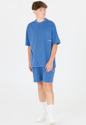 Blå bomullst-shirt med korta ärmar och rund hals, kombinerad med matchande shorts. Båda plaggen har en diskret logga och dragsko-detalj.