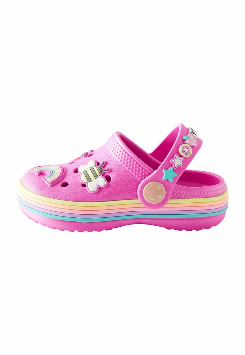 Sabot rose pour enfant avec semelle rayée aux couleurs de l’arc-en-ciel, décoré avec des icônes façon breloques incluant une abeille, un arc-en-ciel, des étoiles et un visage souriant sur la bride.