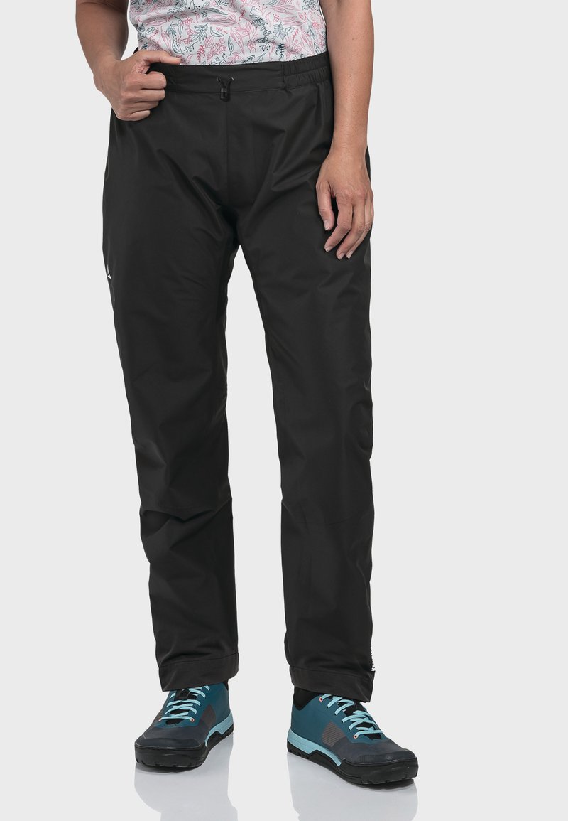 Schwarze wasserdichte Hose mit elastischem Bund und vorderem Reißverschluss. Glatte Textur, lockere Passform mit geraden Beinen. Mit einem Logo akzentuiert.