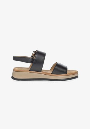 Black leather sandal with two wide straps, cushioned tan sole, slight wedge heel, and adjustable back strap with buckle.