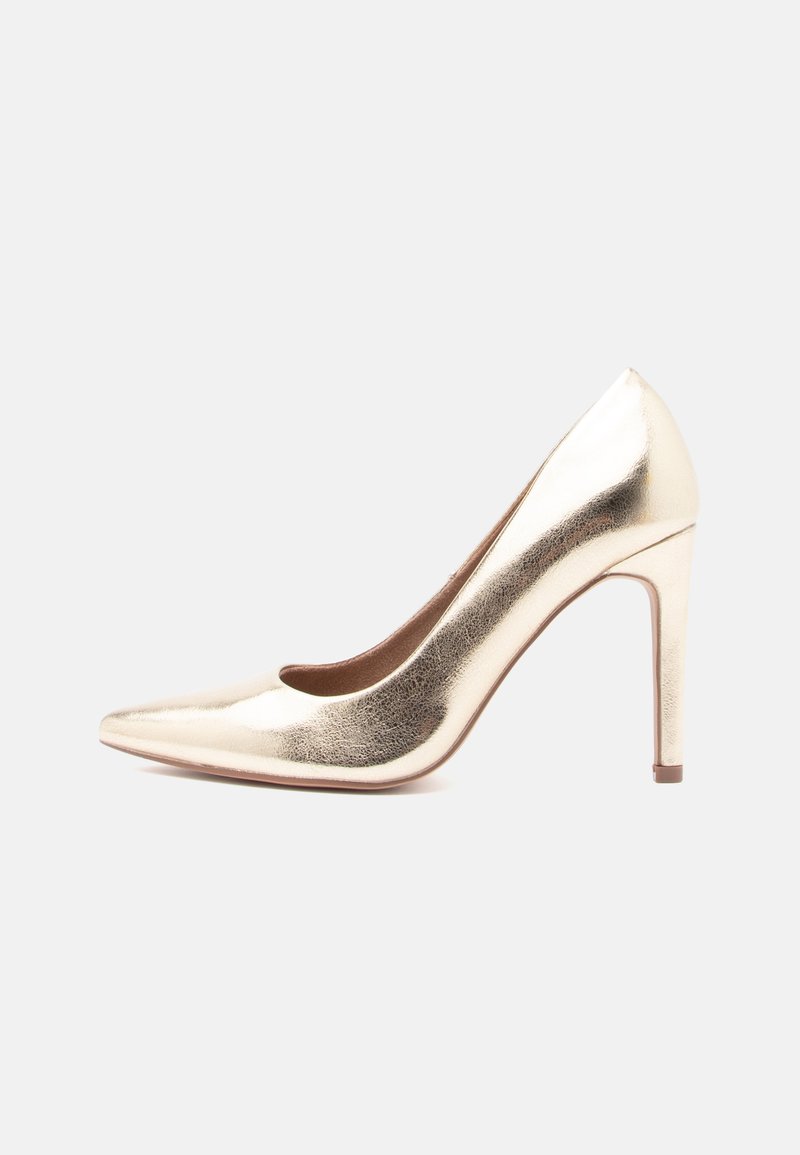 Pumps dourados metálicos de salto alto com bico afinado e salto stiletto fino, exibidos em perfil lateral sobre fundo branco.