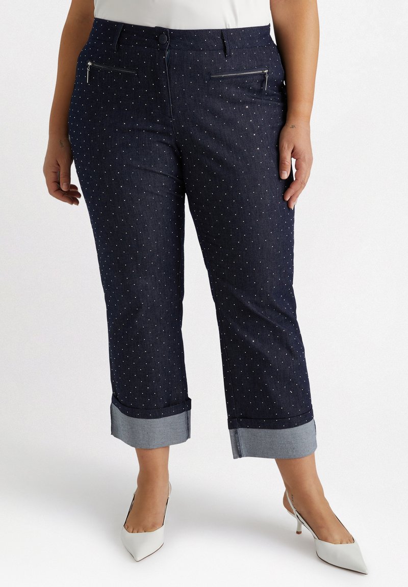 Mörk denimbyxor med vita prickar, korta med vikit fåll och dragkedjefickor fram. Platt midja och mjuk textur.