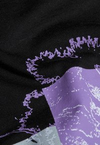 Sort stof har en struktureret overflade med et grafisk design i lavendel og grå, der viser abstrakte former og mønstre.