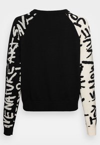 Schwarzer Pullover mit weißem grafischem Text auf einem Ärmel, Strickstruktur, Rundhals, gerippter Saum und Bündchen, kontrastierendes Ärmel-Design.