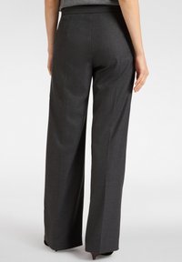 Donkergrijze, wijde broek met een gladde textuur, voorzien van een platte tailleband en twee achterzakken, op maat gemaakt voor een gestructureerde pasvorm.