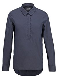 Chemise manches longues bleu marine avec col pointu et patte de boutonnage dissimulée, taillée pour une coupe décontractée.