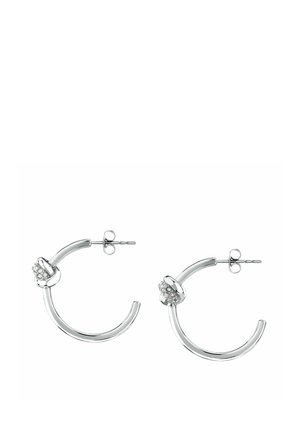 Orecchini a mezza luna in argento con un piccolo dettaglio a nodo accentuato da cristalli trasparenti vicino ai perni, chiusura a farfalla.