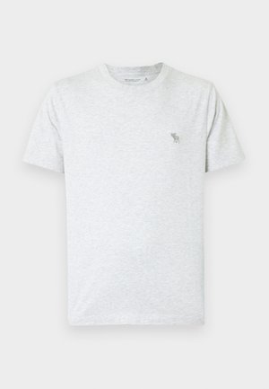 T-shirt gris clair en coton doux, doté d'un col rond et de manches courtes. Petit logo d'animal vert sur le haut à gauche de la poitrine.