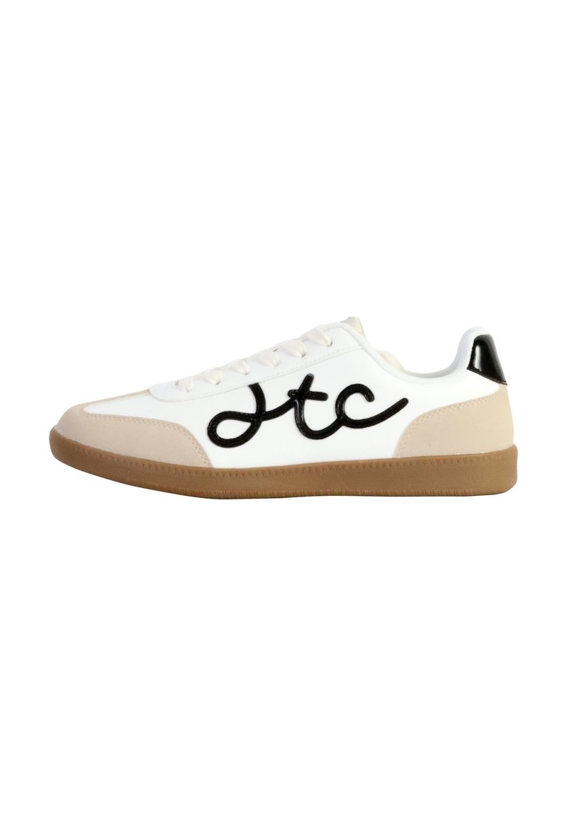Sneaker bianca con logo nero, dettagli beige, suola in gomma testurizzata e chiusura con lacci. Parte superiore liscia e cappuccio del tallone lucido.