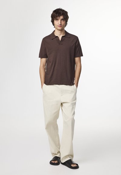 Polo shirt marron à manches courtes, pantalon crème à rayures et sandales noires en cuir. Ajustement simple et décontracté avec un design de col classique.