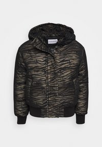 Vadderad huvmössa i svart och olivgrön, med tigerstripe-mönster och Calvin Klein-logotyp. Ribbad mudd och fåll. Dragkedjestängning.
