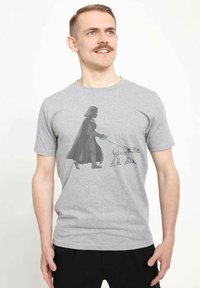Gray t-shirt featuring a graphic of a figure dressed in black with a cape walking a small, robotic dog on a leash.