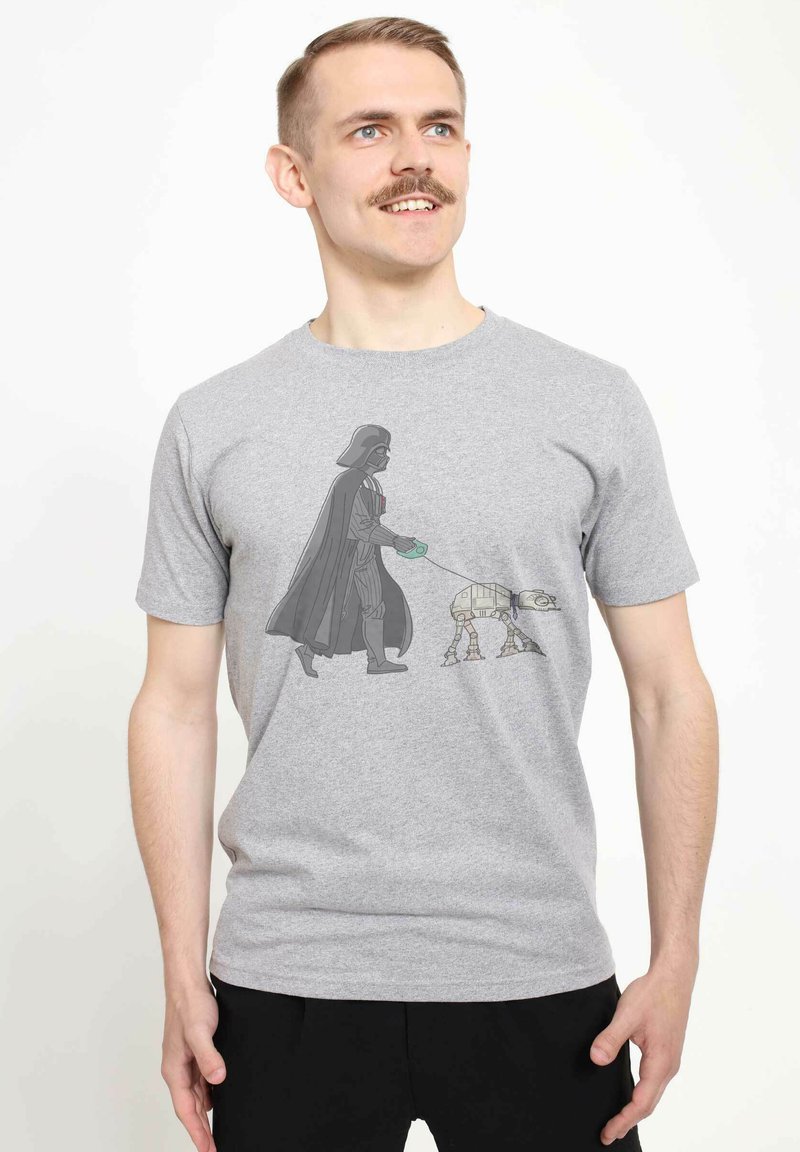Gray t-shirt featuring a graphic of a figure dressed in black with a cape walking a small, robotic dog on a leash.