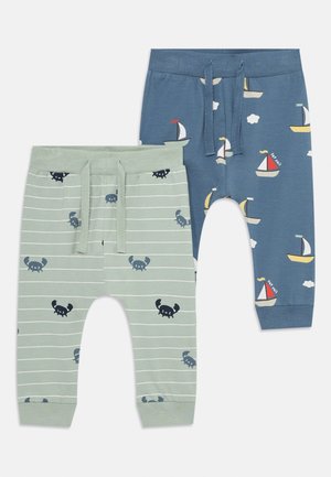 Due paia di pantaloni per bambini. Uno di colore verde chiaro con motivo a righe e grafiche di granchi; l'altro di colore blu scuro con disegni di barche e nuvole.