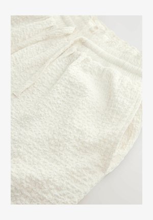 Țesătură albă texturată cu o suprafață zbârcită, având un design moale, ușor și o strălucire subtilă. Marginea este netedă și terminată cu grijă.