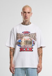 Hvit bomull T-skjorte med oversized passform, grafisk trykk med "Champions 1993" og "Out of this World K-LX", samt rullet erme.