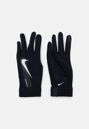 Guantes deportivos negros hechos de tela texturizada, con un logotipo gris de Nike y acentos laterales de agarre. Puños ajustables para un ajuste seguro.
