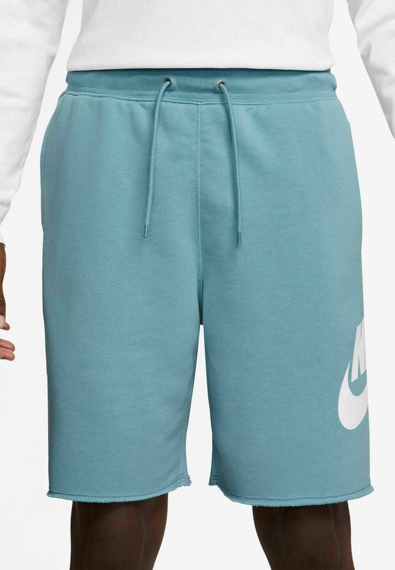 Shorts Nike di colore azzurro chiaro realizzati in tessuto morbido, dotati di vita con coulisse, tasche laterali e un grande logo bianco sulla coscia sinistra.
