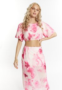 Crop top tie-dye rosa e bianco con maniche corte e gonna alta abbinata, caratterizzato da una texture morbida e una silhouette aderente.
