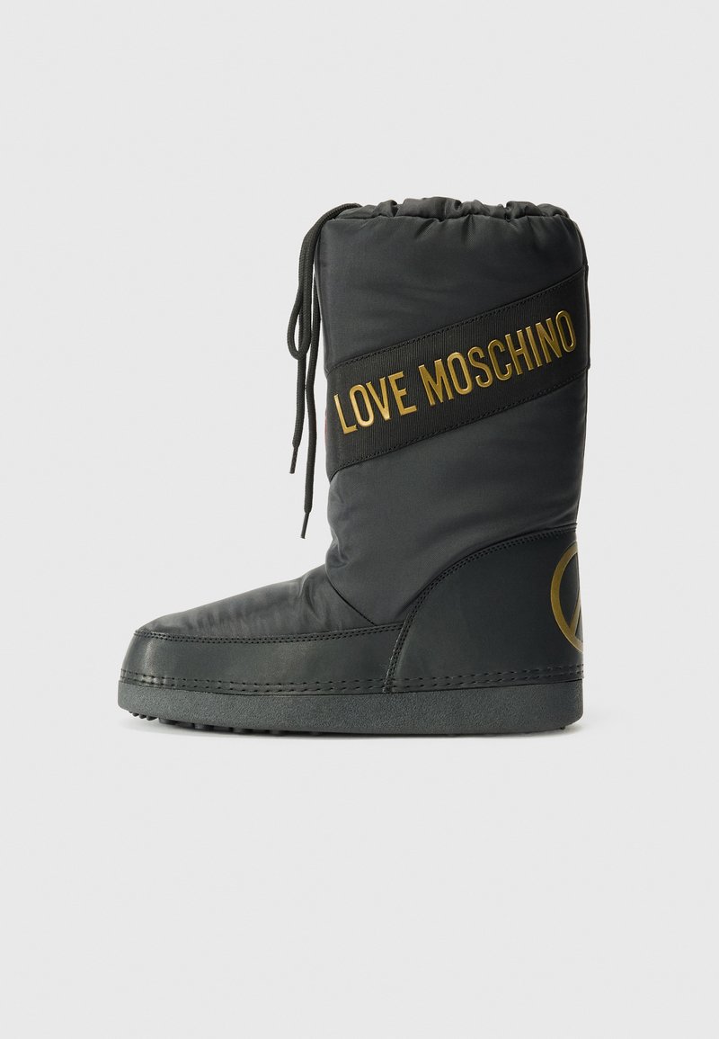 Fekete párnázott csizma, amely húzózsinórral záródik, arany "LOVE MOSCHINO" szalaggal és kör alakú logóval az oldalon. Lapos talp.