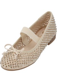 Bailarinas beige con material suave, adornadas con strass transparentes, diseño perforado, banda elástica y un pequeño lazo decorativo.