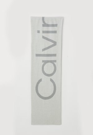 Bufanda de color gris claro con un gran logotipo estilizado de "Calvin" en un gris más oscuro. Textura suave y con forma rectangular larga. Diseño sencillo.
