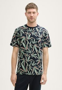 Korte mouwen t-shirt in marineblauw met een bladpatroon in groen en rood. Gemaakt van katoen; heeft een ronde hals en een relaxte pasvorm.