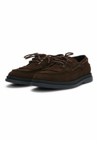 Braune Wildlederschuhe mit abgerundeter Spitze, Schnürdesign und dekorativen Nähten. Mit einer schwarzen Gummisohle und Metallösen.
