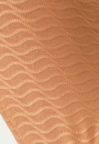 Tecido texturizado em uma cor pêssego quente, com um padrão de ondas e costura em relevo. Material liso e elástico adequado para vestuário.