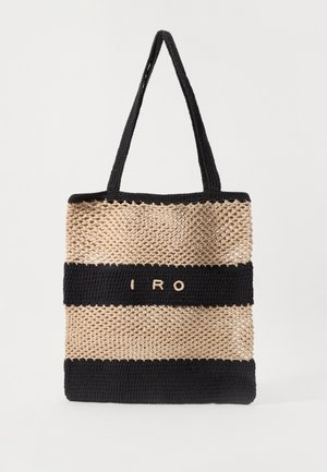 Woven tote bag featuring alternating beige and black stripes, with the letters "IRO" in cream on a black band. Dual black handles.
