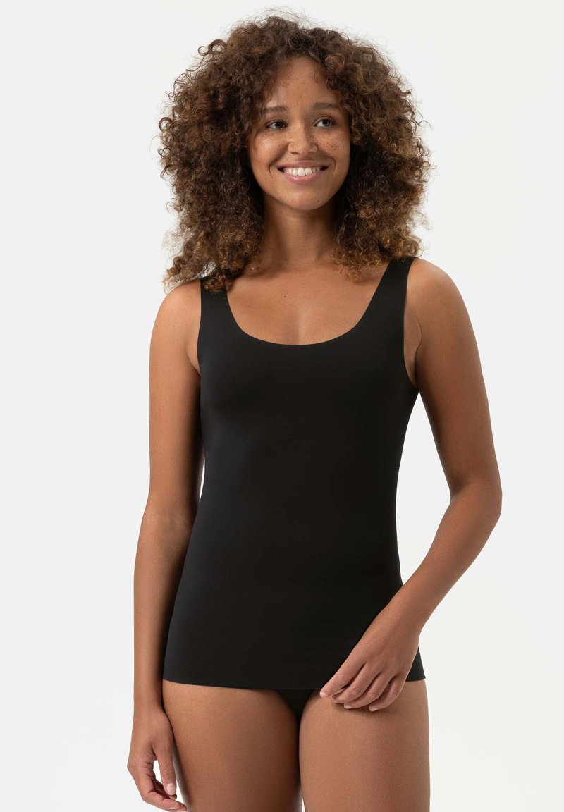 Zwarte tanktop van glad materiaal met een ronde halslijn en brede schouderbanden. Heeft een aansluitende pasvorm en wordt gedragen met bijpassend ondergoed.